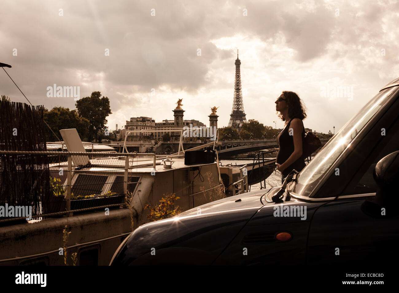 Femme enceinte seule à Paris, sans doute la plus romantique des villes du monde. Dans l'avant-plan, un mini Coupé S. Banque D'Images