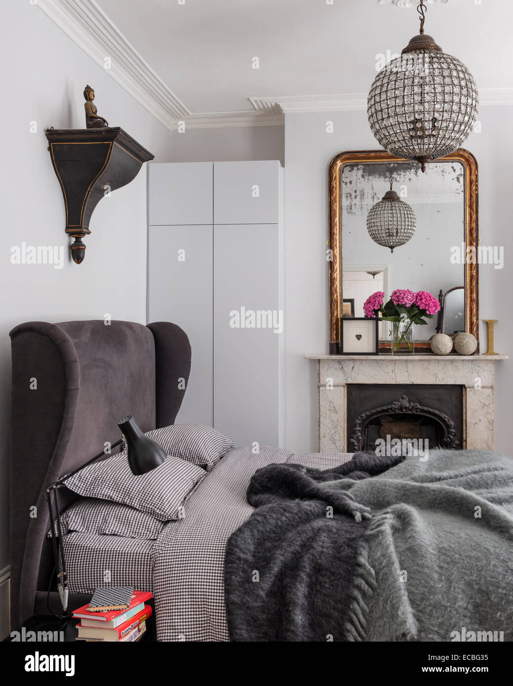 Lit rembourré de luxe de sofa.com dans chambre avec cheminée d'origine, et la culpabilité de stockage intégré miroir encadré. Le mohair bla Banque D'Images