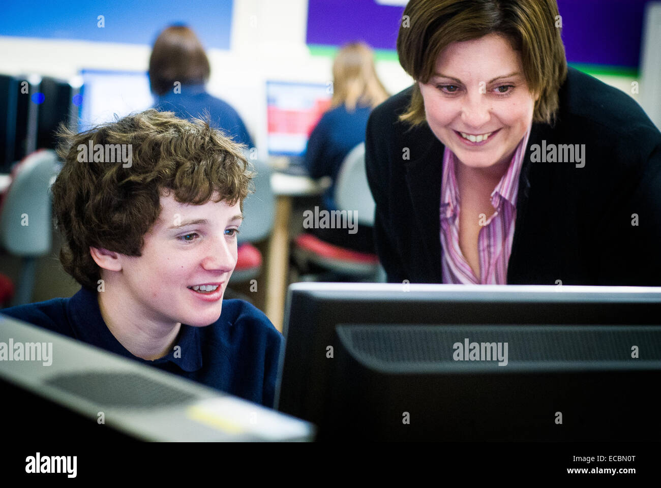 Aider les enseignants à travailler sur ordinateur d'étudiant Banque D'Images