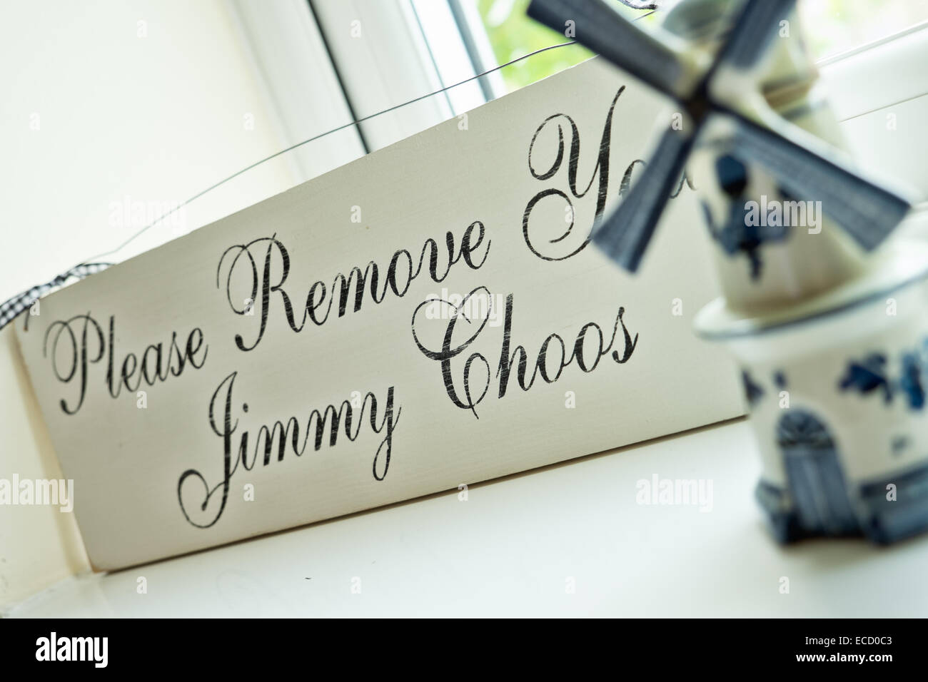 Un mignon vintage signe sur un rebord de fenêtre, proclamant le jeu de mots, veuillez déposer votre Jimmy Choos, Banque D'Images