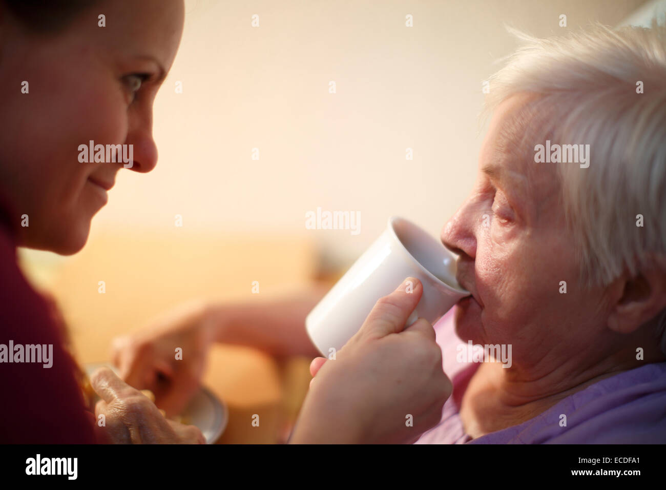 Femme, 85 ans, dans une maison de soins infirmiers, au petit déjeuner, avec l'appui d'une infirmière en gériatrie, Banque D'Images