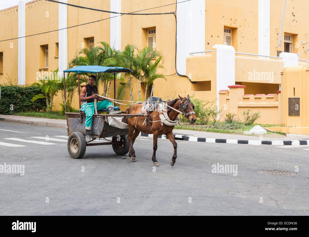 La conduite d'un homme cheval et panier par la caserne de Moncada, jaune avec des impacts de balles visibles dans les murs, Santiago de Cuba Banque D'Images