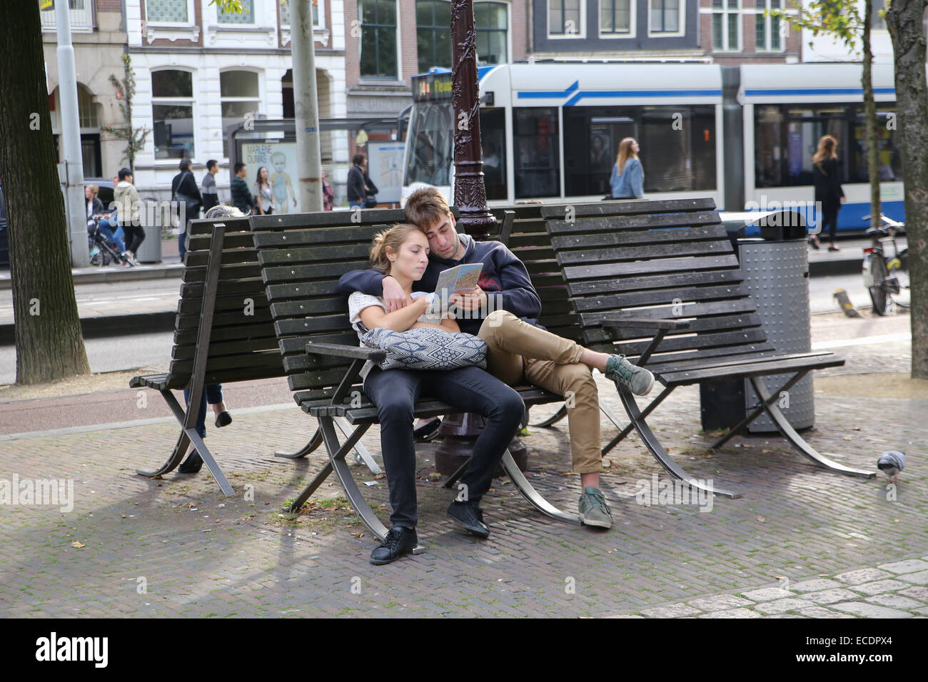 Couple de touristes fatigués assis banc reading map Banque D'Images