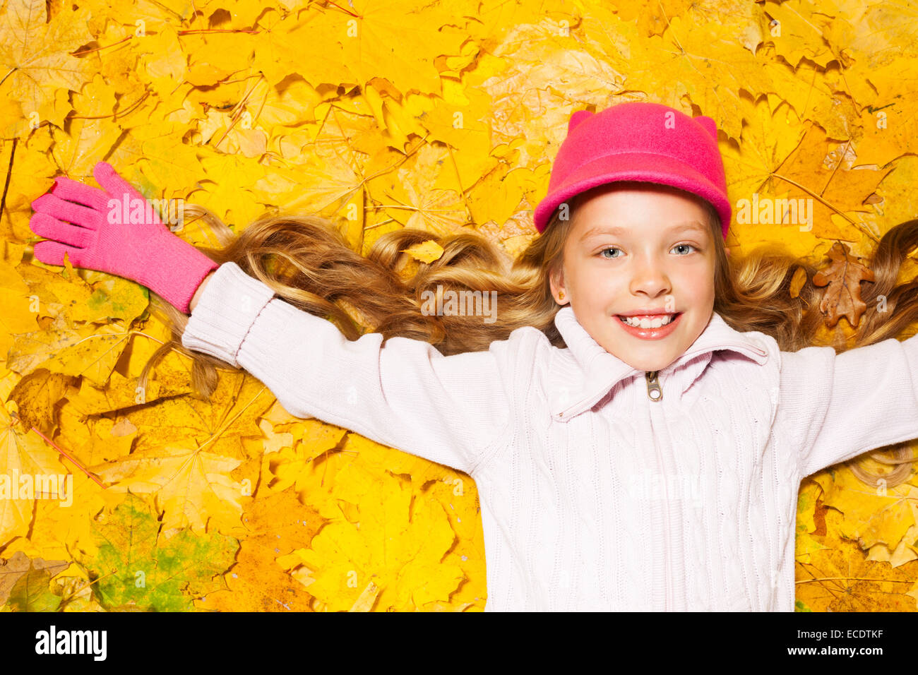 Happy smiling girl sur les feuilles d'automne Banque D'Images