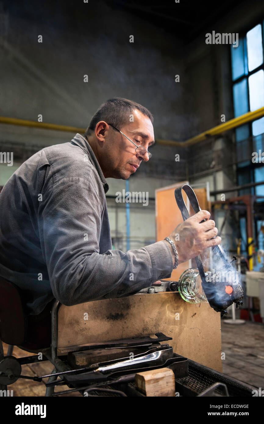 Homme souffleur de verre à l'usine de verre Moser et l'artisanat du verre soufflé dans des gobelets de cristal, Karlovy Vary (Karlsbad), République Tchèque Banque D'Images