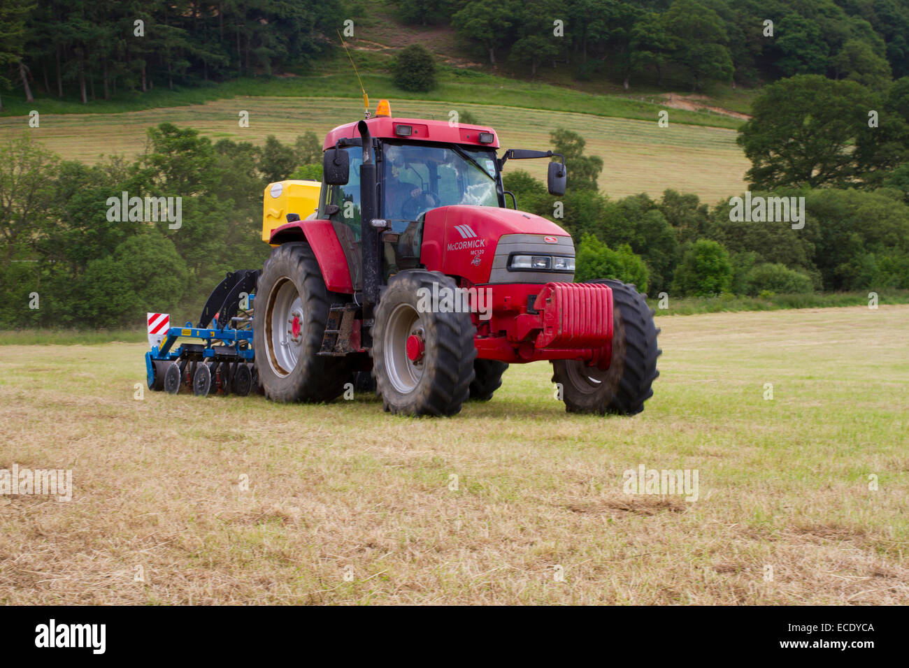 Entrepreneur avec un tracteur McCormick MC120 et une Agriseeder Erth emplacement de forage de précision semoir de trèfle dans un champ. Banque D'Images