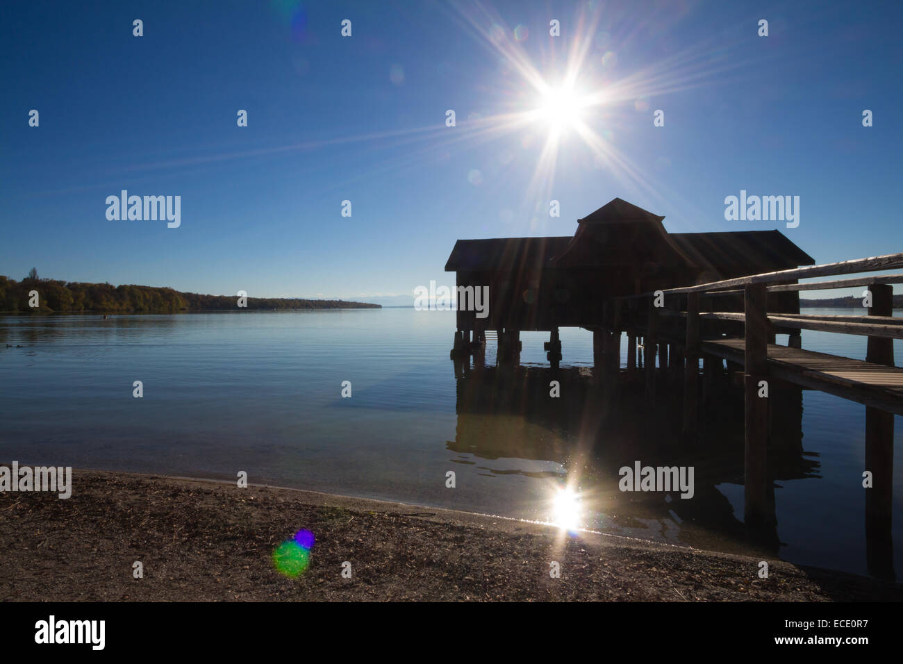 Jetée du lac coucher de soleil silhouette boathouse Banque D'Images