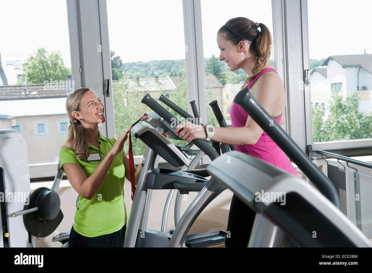 Deux femmes studio fitness sport formateur aidant Banque D'Images