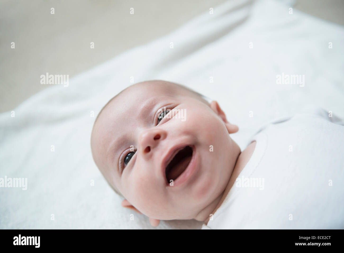 Baby Boy lying on bed, smiling Banque D'Images