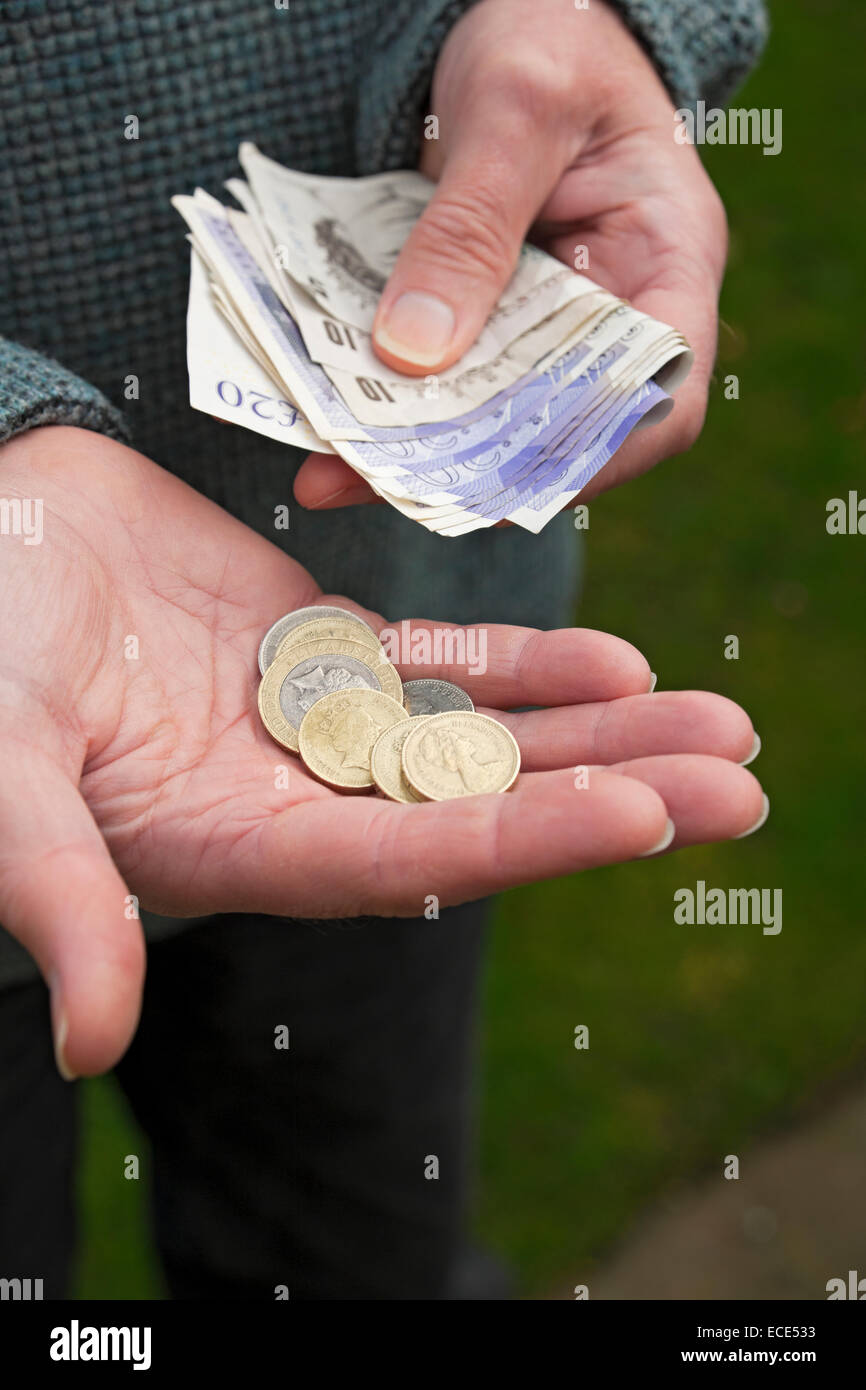 Gros plan de Man holding English money billets billets pièces en espèces Angleterre Royaume-Uni GB Grande-Bretagne Banque D'Images