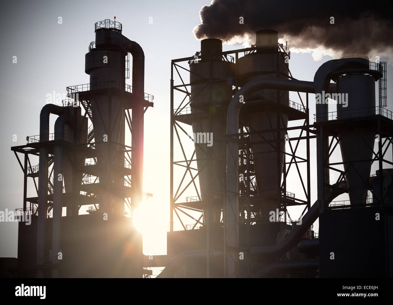 Cheminées de fumée silhouettes contre le soleil. La pollution de l'air concept. Banque D'Images