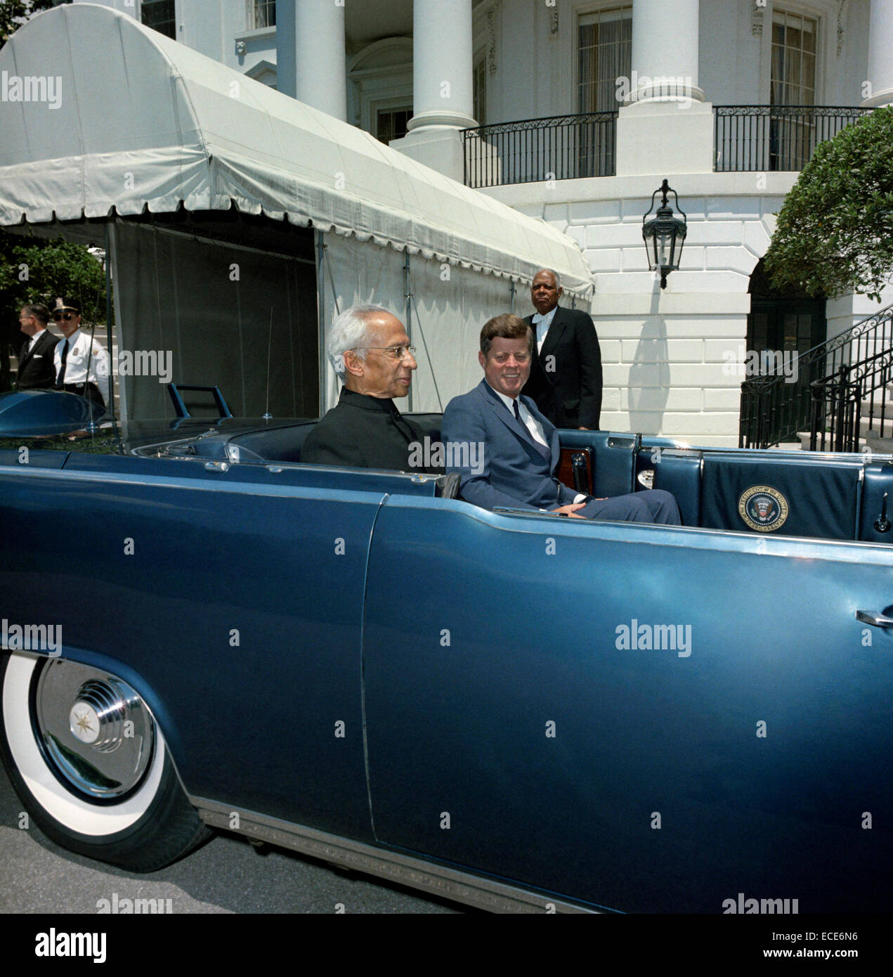 Président américain John F. Kennedy et le président de l'Inde, le Dr Sarvepalli Radhakrishnan, s'asseoir sur le siège arrière de la limousine présidentielle avant le début d'une parade en l'honneur du président Radhakrishnan au portique sud de la Maison Blanche le 4 juin 1963 à Washington, DC. Adjoint spécial au président Kennedy, John J. McNally (tournant la tête), se tient à l'extrême gauche en arrière-plan ; un membre du personnel de la Maison Blanche se trouve au centre en arrière-plan. Pelouse sud allée, Maison Blanche, Washington, D.C. Banque D'Images