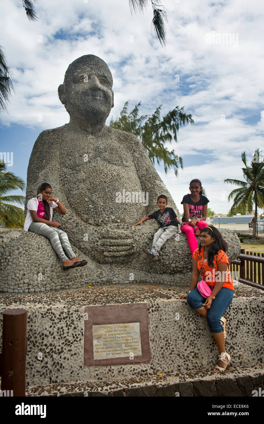 L'Ile Maurice, Mahebourg, front de mer, les enfants de grimper sur la Statue de l'harmonie de Swami Sivananda Banque D'Images