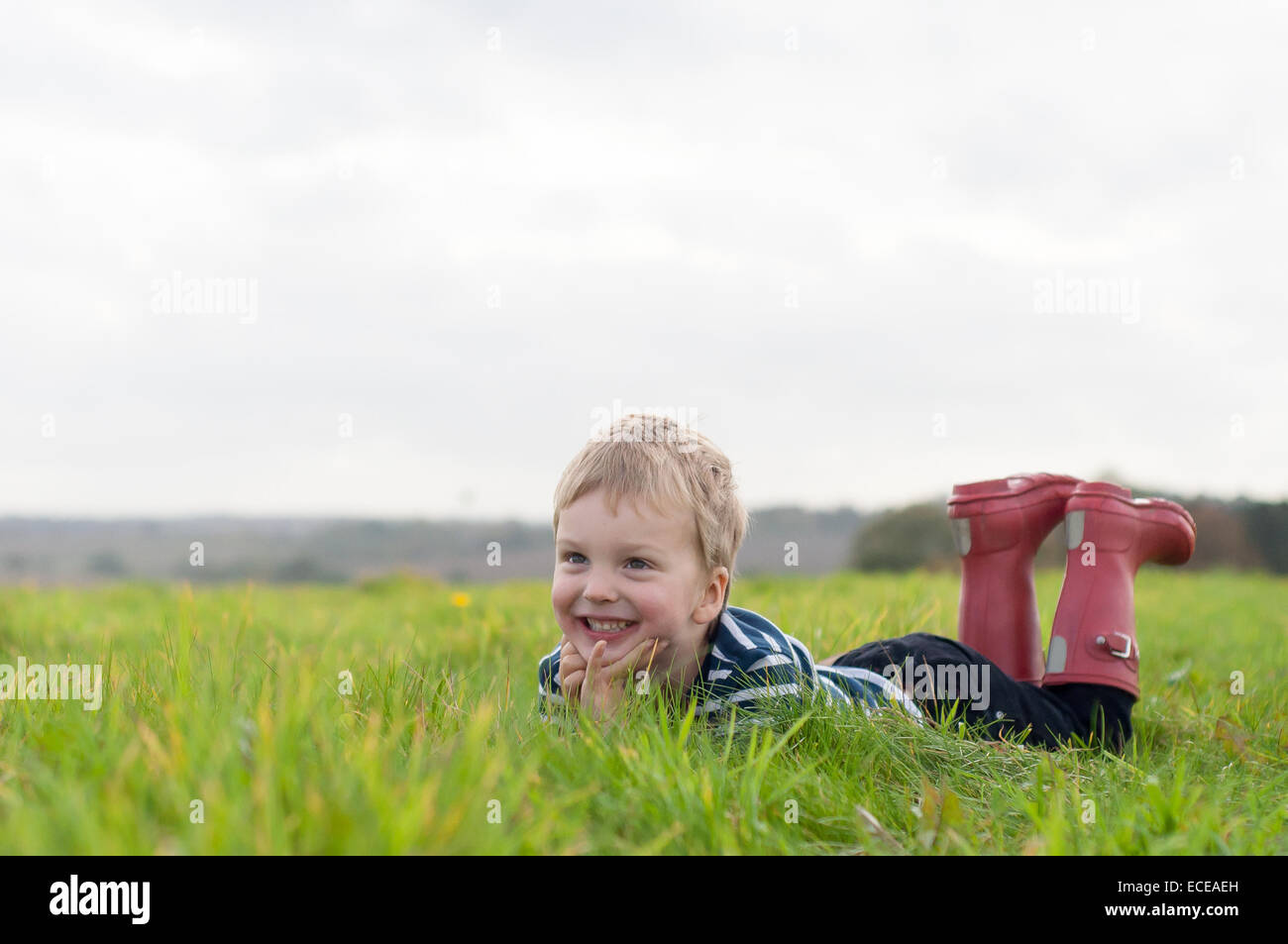 Boy lying in grass Banque D'Images