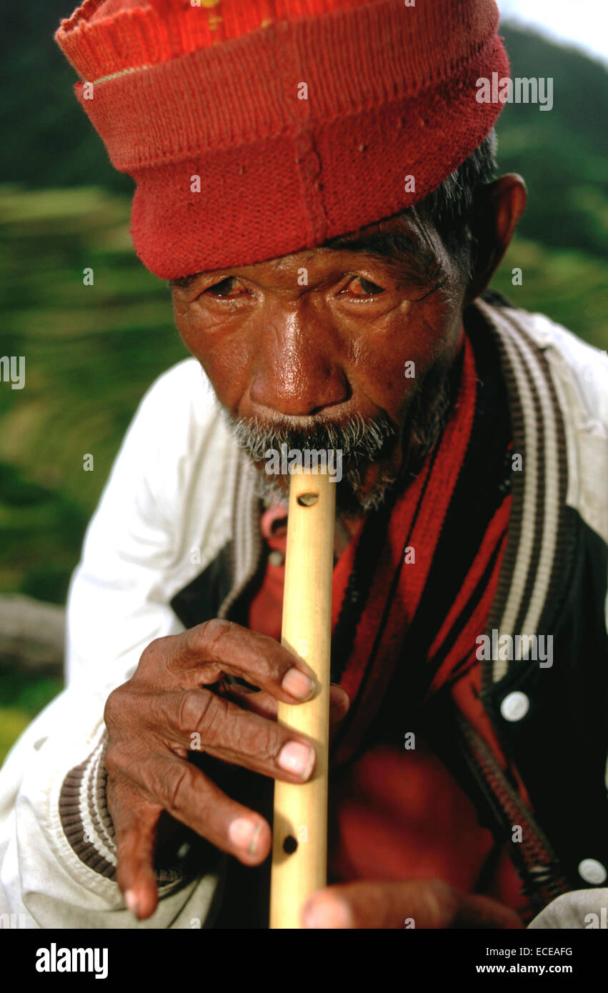 Tribu Ifugao homme jouant de la flûte. Rizières en terrasses. Point de vue. Banaue. Le nord de Luzon. Aux Philippines. Banaue (ou spe Banque D'Images