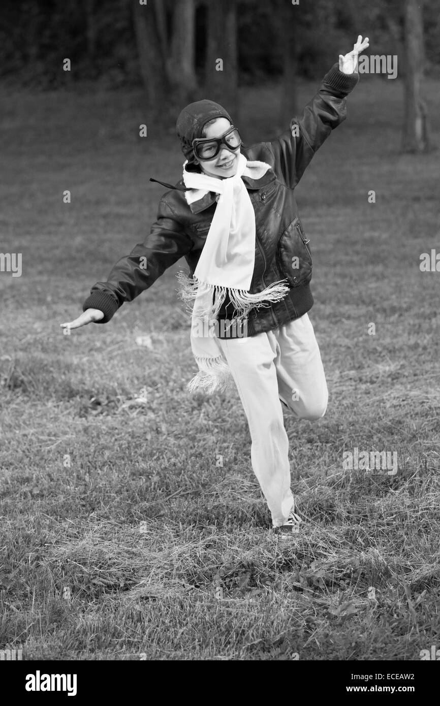 Boy running with arms outstretched prétendant à voler Banque D'Images
