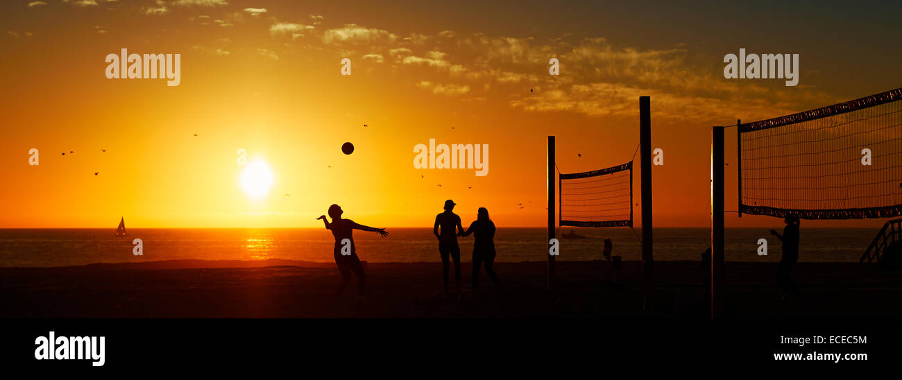 États-unis, Californie, Hermosa Beach, trois personnes jouer au volleyball, découpé sur le coucher du soleil Banque D'Images