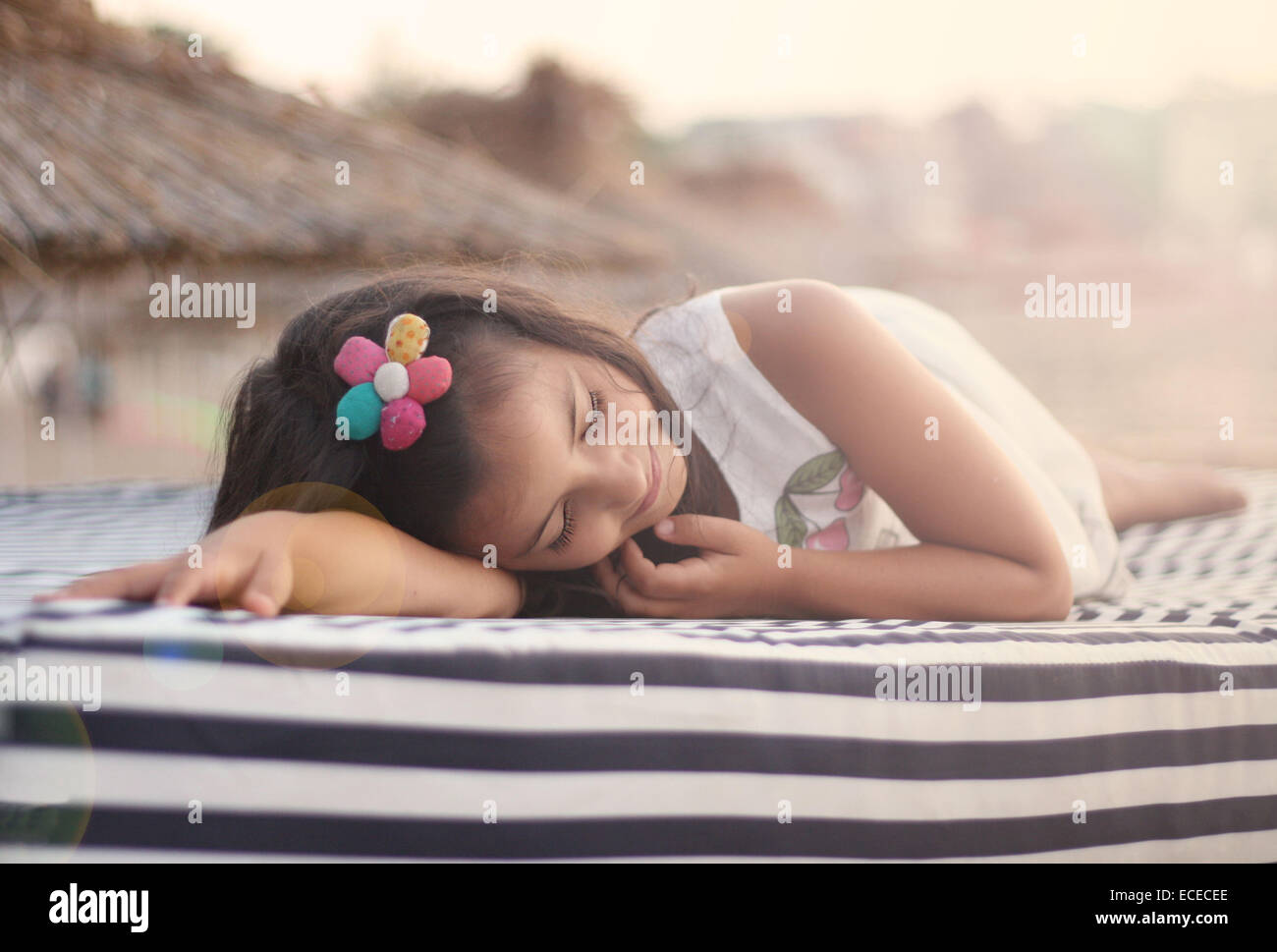 Girl allongé sur un transat sur la plage Banque D'Images