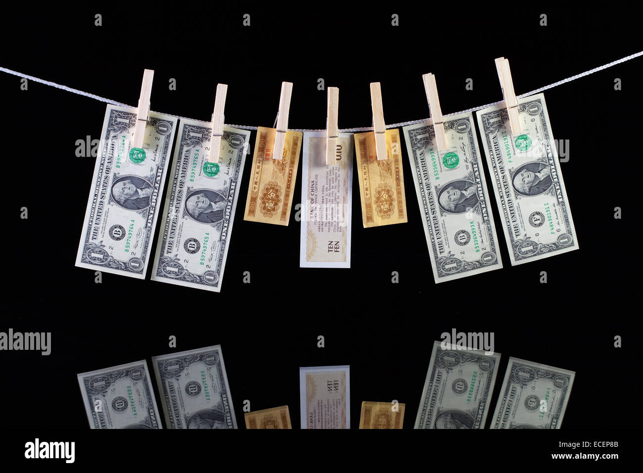 Dirty dollar US et Chine billets suspendu à une corde et se reflétant dans la vitre Banque D'Images