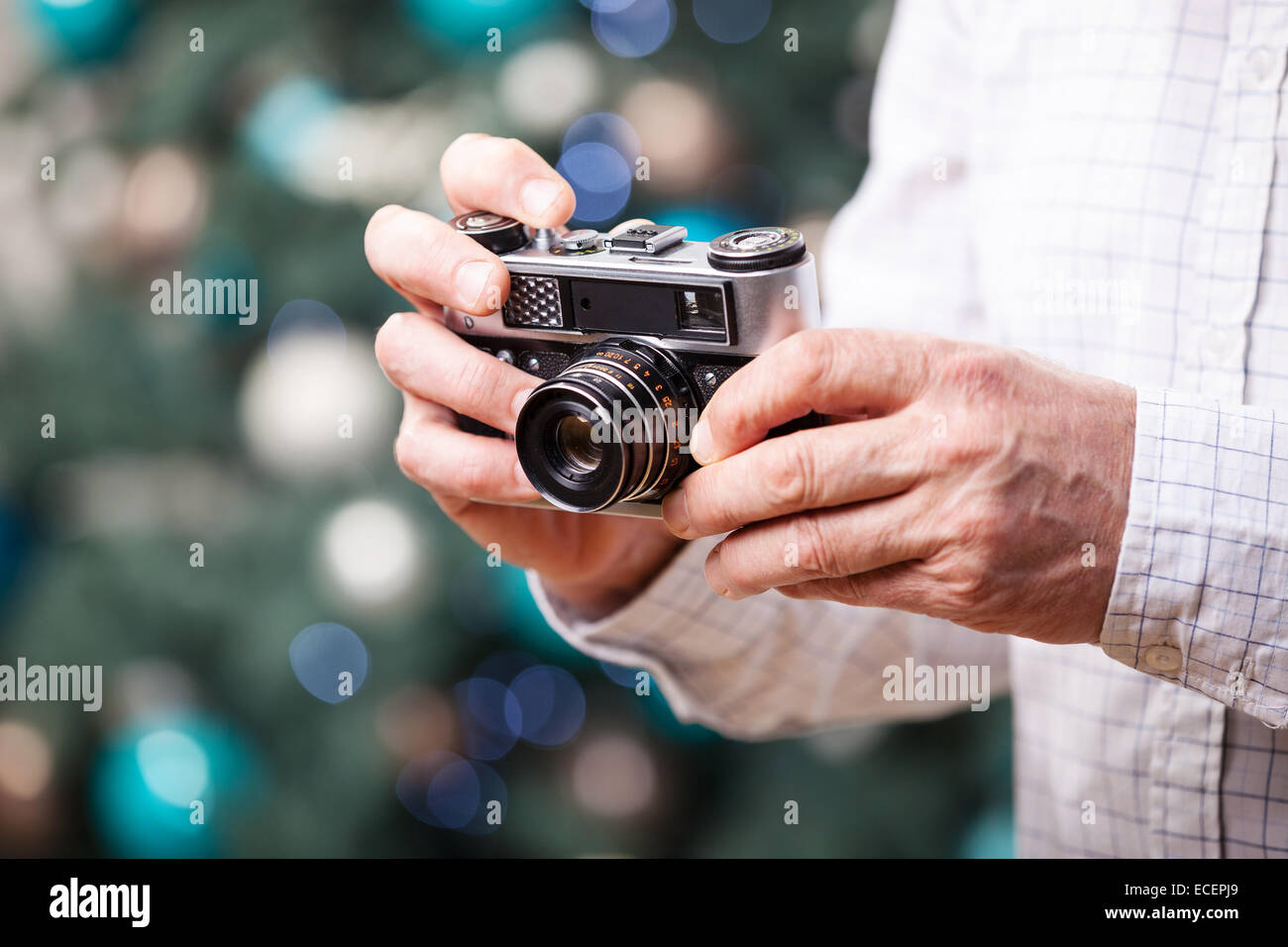 Portrait de l'homme contre l'appareil photo rétro holding Christmas background Banque D'Images