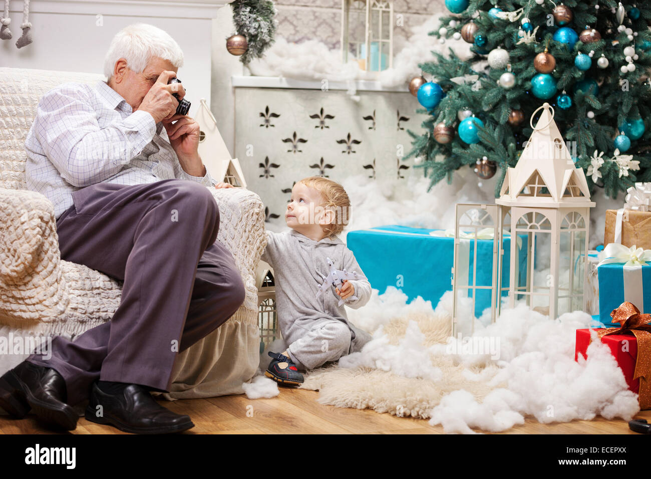 Man photo de son tout-petit-fils alors qu'il était assis près de l'arbre de Noël à la maison Banque D'Images