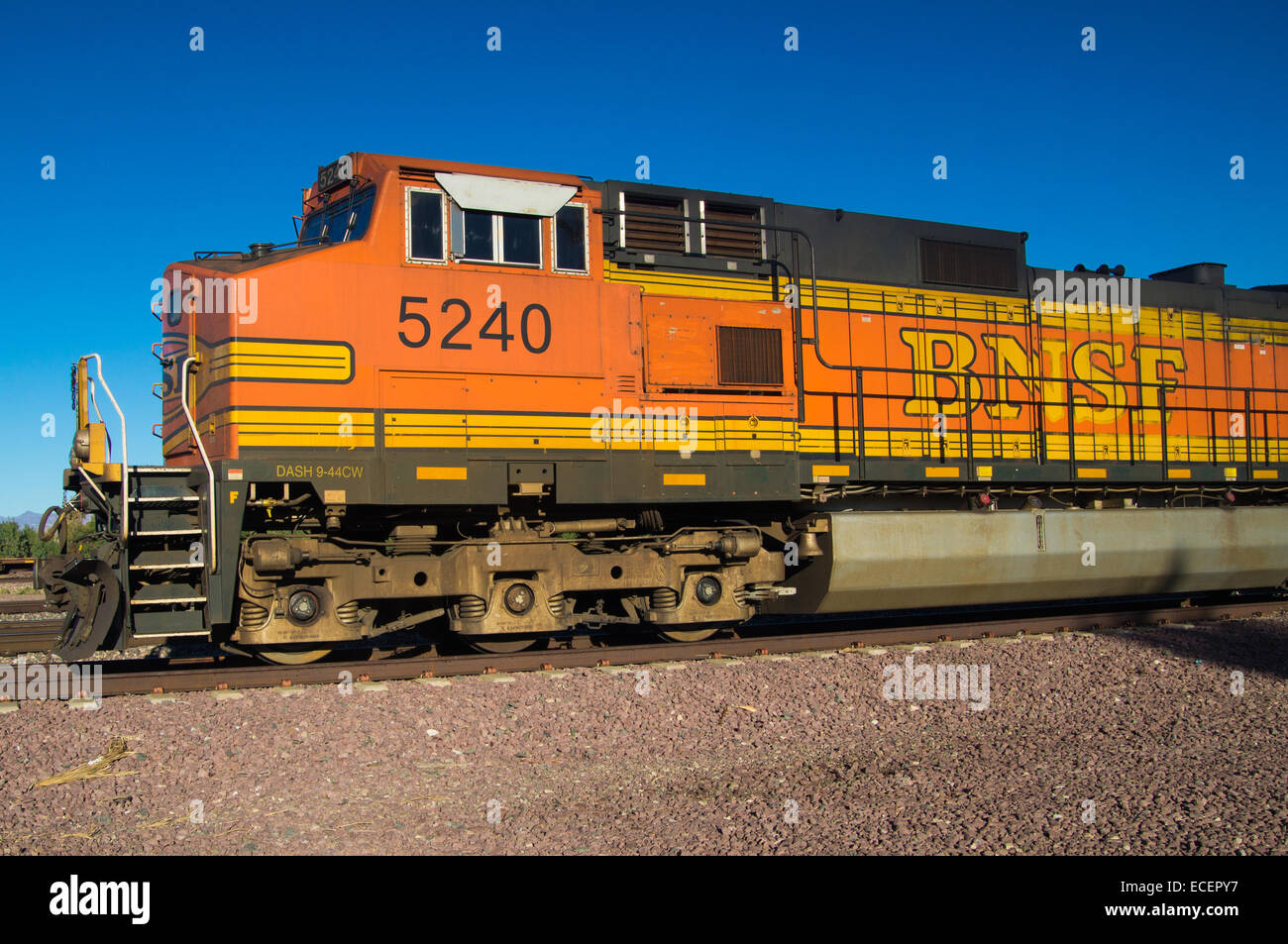 Orange et jaune distinctif Burlington Northern Santa Fe train marchandises locomotive no. 5240 sur les pistes à la ville d'aiguilles Banque D'Images