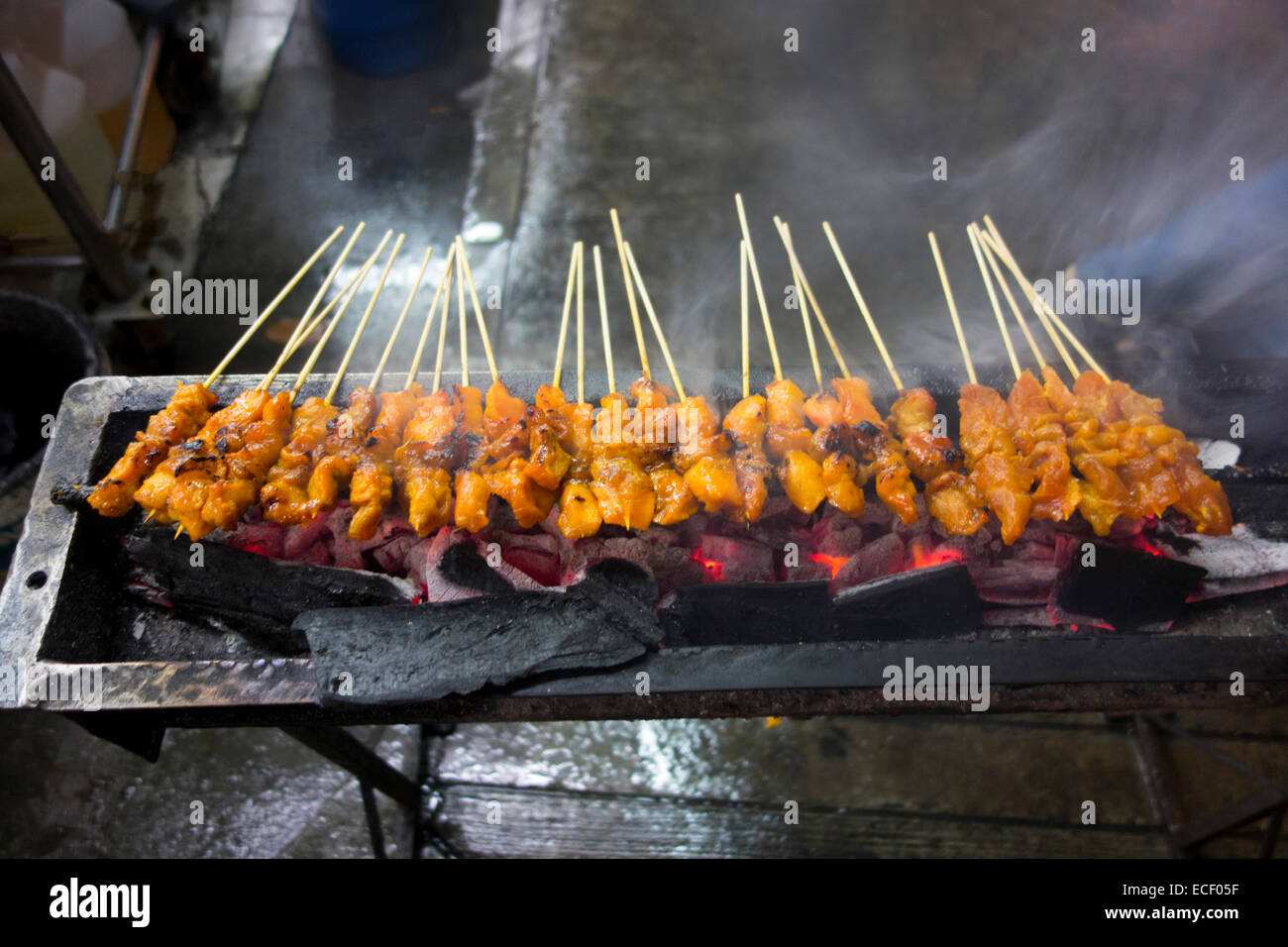 Bâtonnets de poulet satay épicé sur un gril barbecue charbon en Asie Banque D'Images