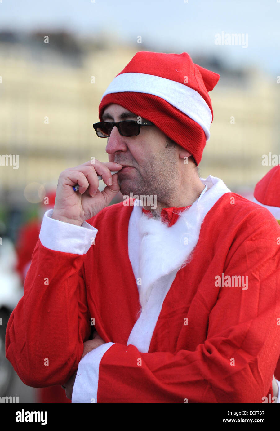 Hove, Brighton, Sussex, UK. 13 Décembre, 2014. Le temps d'une bouffée d'une cigarette électronique avant de prendre part à l'assemblée annuelle de bord sur bord de mer Santa Hove ce matin une série de charité Santa Dash va avoir lieu pendant la période des fêtes en Bretagne chaque année. Crédit : Simon Dack/Alamy Live News Banque D'Images