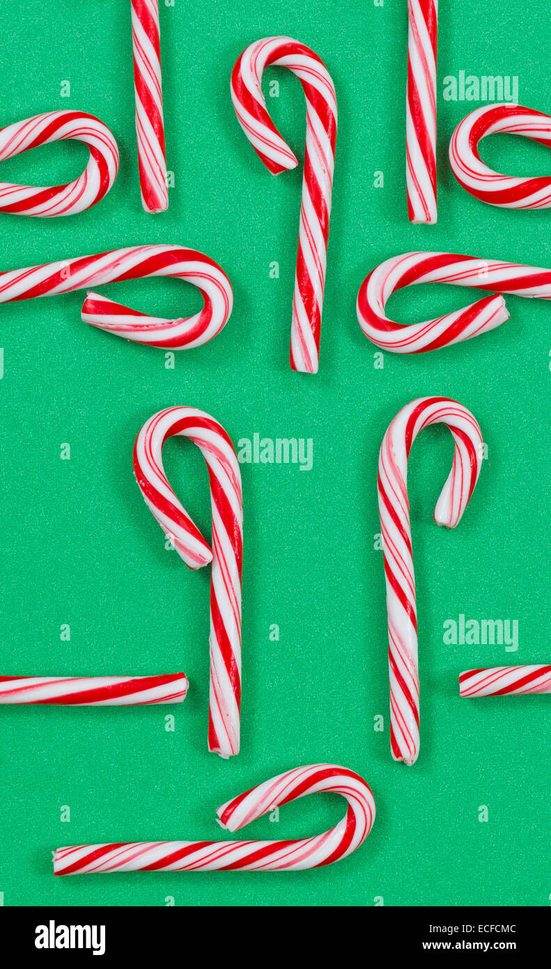 Vue de dessus l'orientation verticale tourné de rouge et blanc dépouillé des cannes de Noël sur un solide fond vert. Modèles aléatoires Banque D'Images