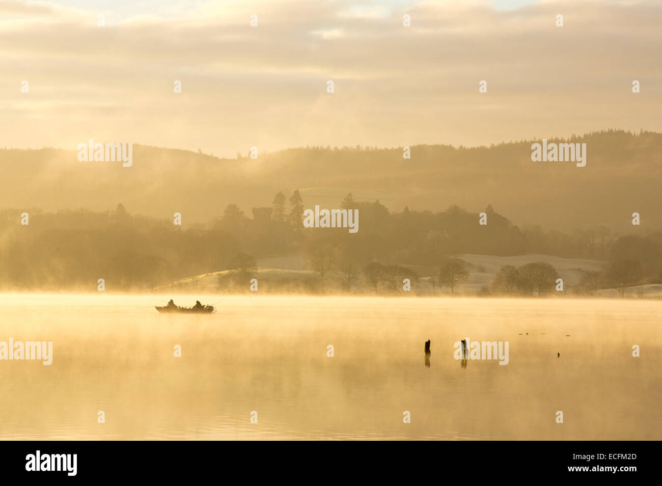 Lever du soleil sur les hommes dans un bateau de pêche sur le lac Windermere à Ambleside, Lake District, UK. Banque D'Images