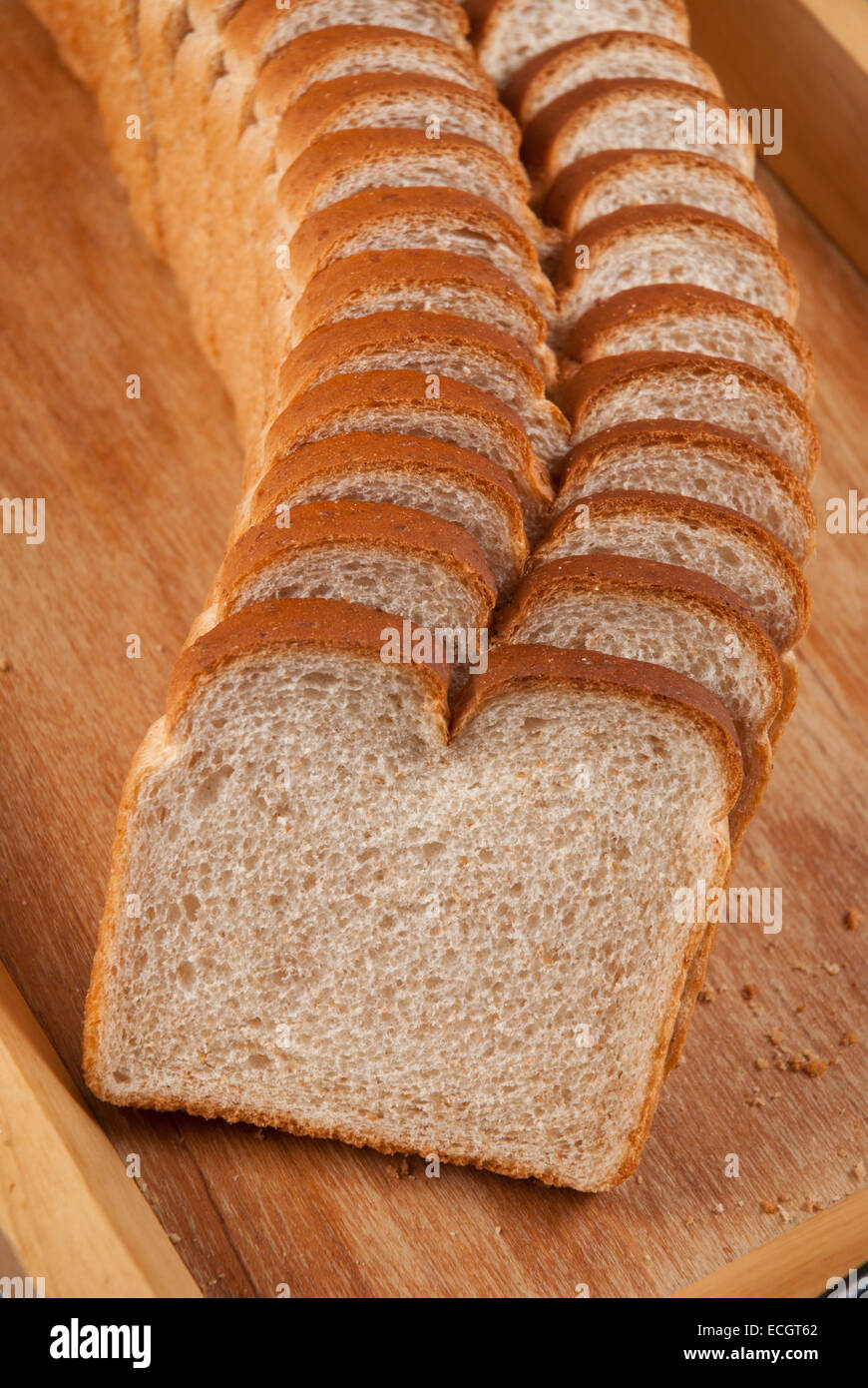Tranches de pain de blé sur planche de bois Banque D'Images