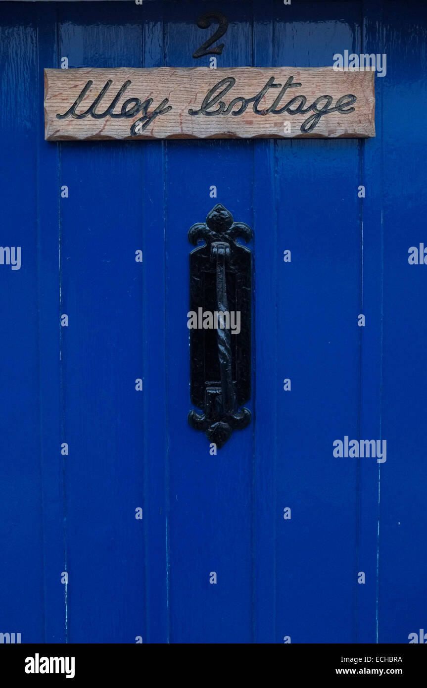 Porte en bois bleu avec boîte aux lettres verticale et heurtoir, chambre numéro 2 et nommé peut Cottage en bois sculpté signe. Banque D'Images