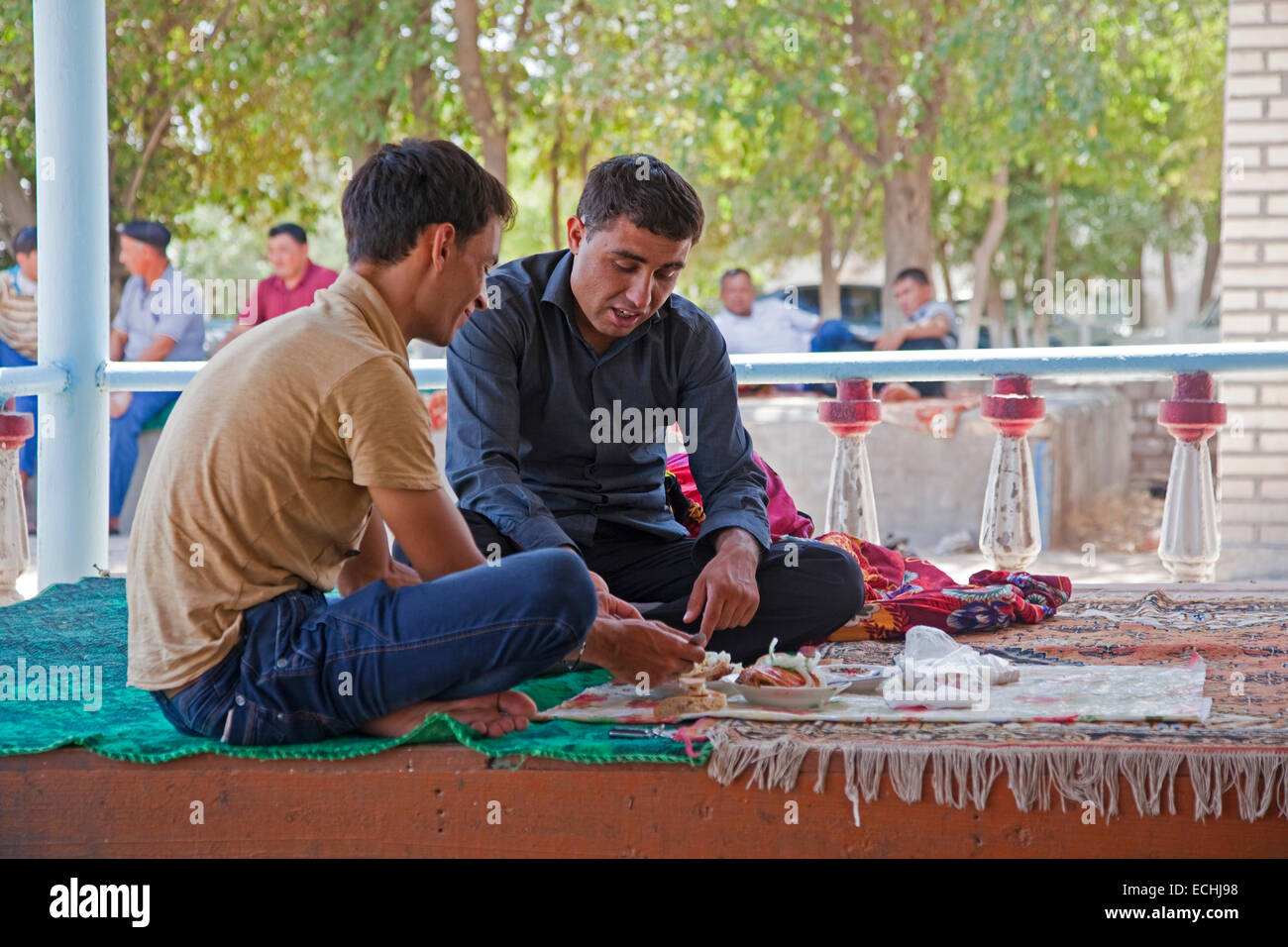 Deux ayant turkmène le déjeuner dans un restaurant traditionnel arabe par assis sur la table, le Turkménistan Banque D'Images