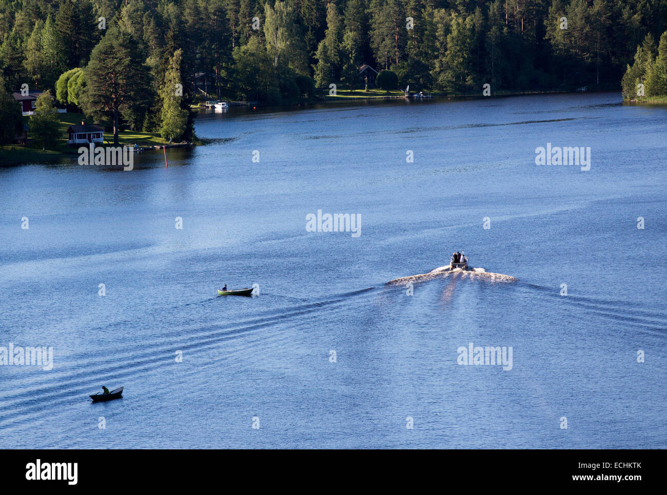 Vue aérienne d'un bateau à moteur passant deux pêcheurs sur barques / patins / canot / canots pneumatiques , Finlande Banque D'Images