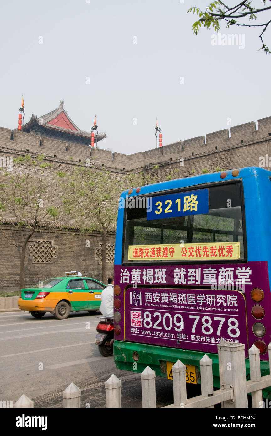 Un bus multicolore dans les rues de Xi'an en Chine devant les anciens murs de cette ville de la route de la soie Banque D'Images