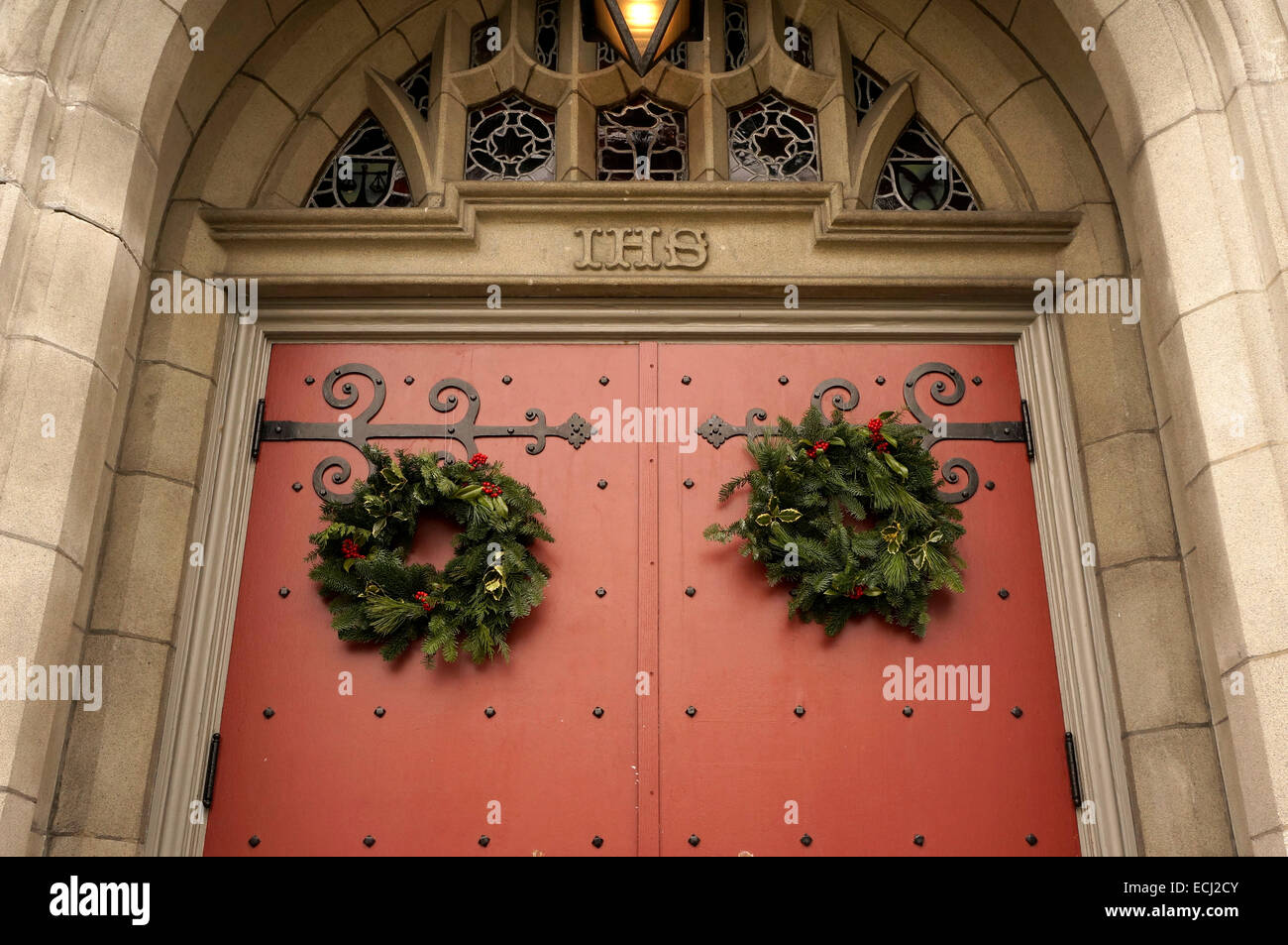 Vert et Rouge traditionnelle couronne de Noël accroché sur la porte de l'Église Unie du Canada, Vancouver, BC, Canada Banque D'Images
