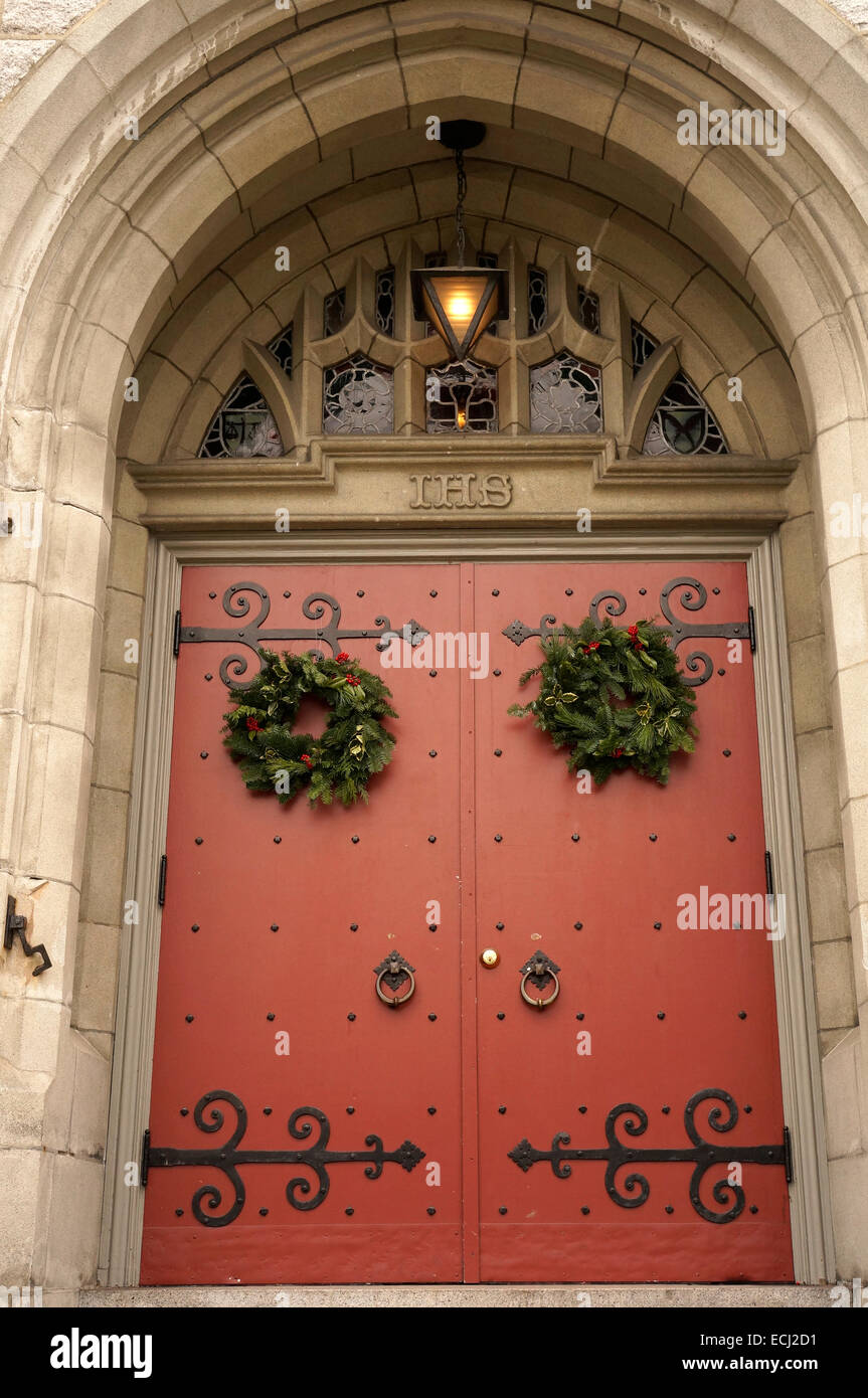 Vert et Rouge traditionnelle couronne de Noël accroché sur la porte de l'Église Unie du Canada, Vancouver, BC, Canada Banque D'Images