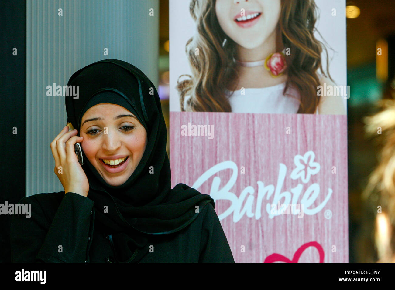 Jeune femme musulmane en foulard noir appelant téléphone mobile, hijab femme, fond dans la publicité sur la Barbie, Prague Tchèque République femme à la mode Banque D'Images