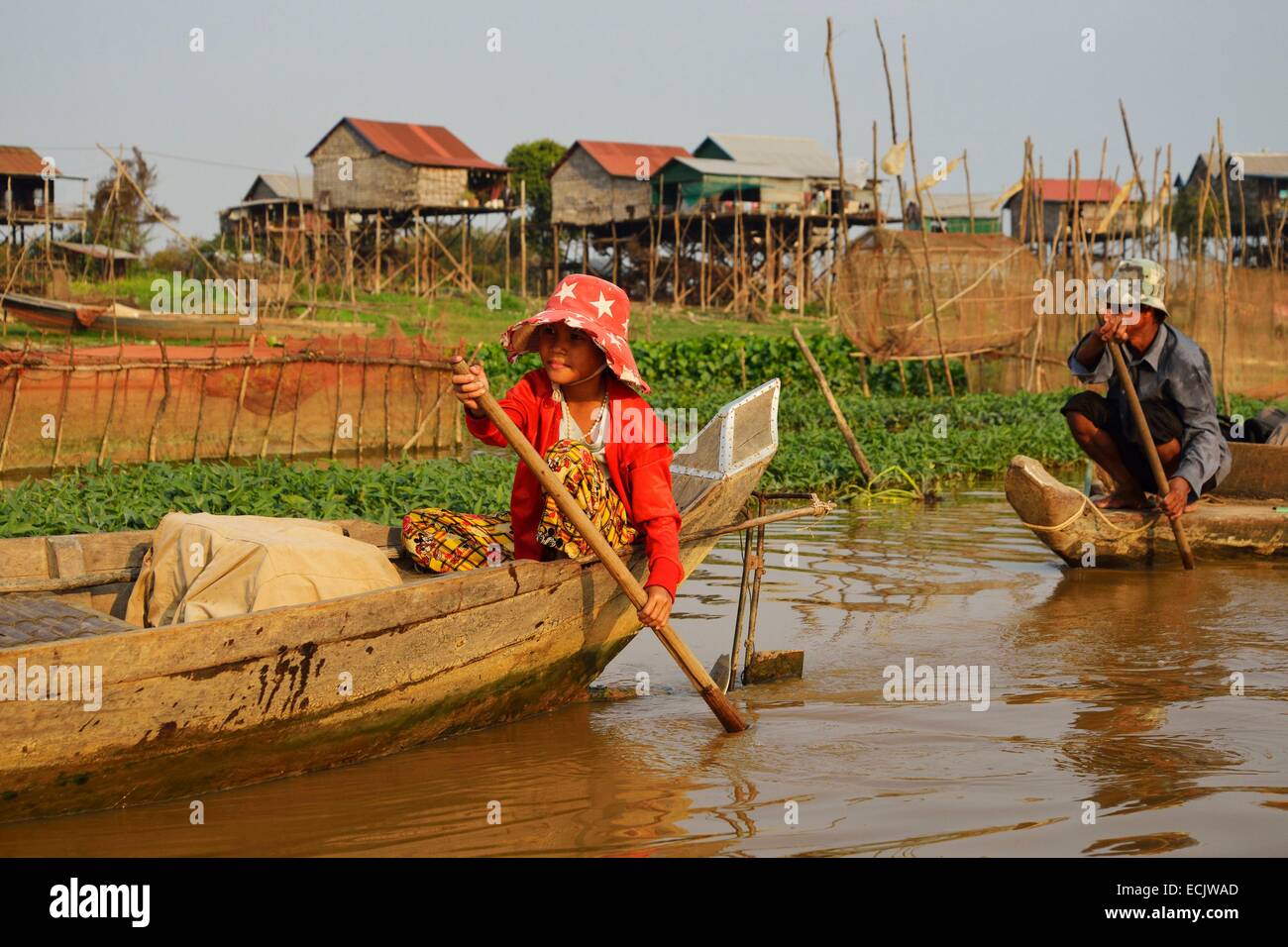 Le Cambodge, la province de Siem Reap, Kompong Kleang, maisons sur pilotis village le long du lac Tonle Sap, les gens se déplaçant le long de chaloupe Banque D'Images