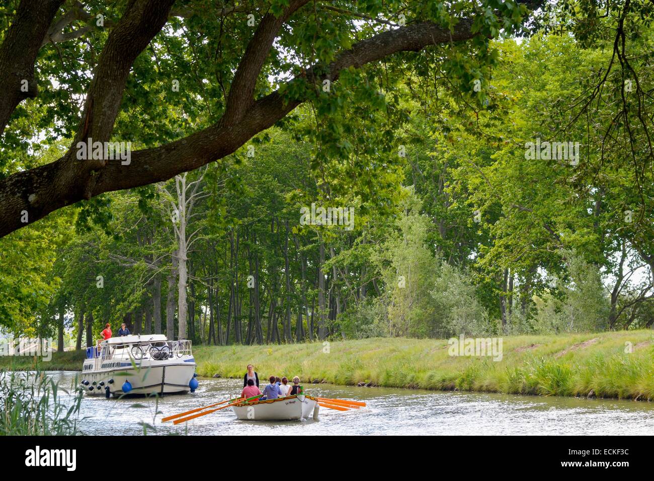 La France, l'Hérault, Narbonne, le Canal du Midi classé au Patrimoine Mondial de l'UNESCO, lieu dit La Croisade, bateau traditionnel suivi d'un yacht avec les arbres en arrière-plan Banque D'Images
