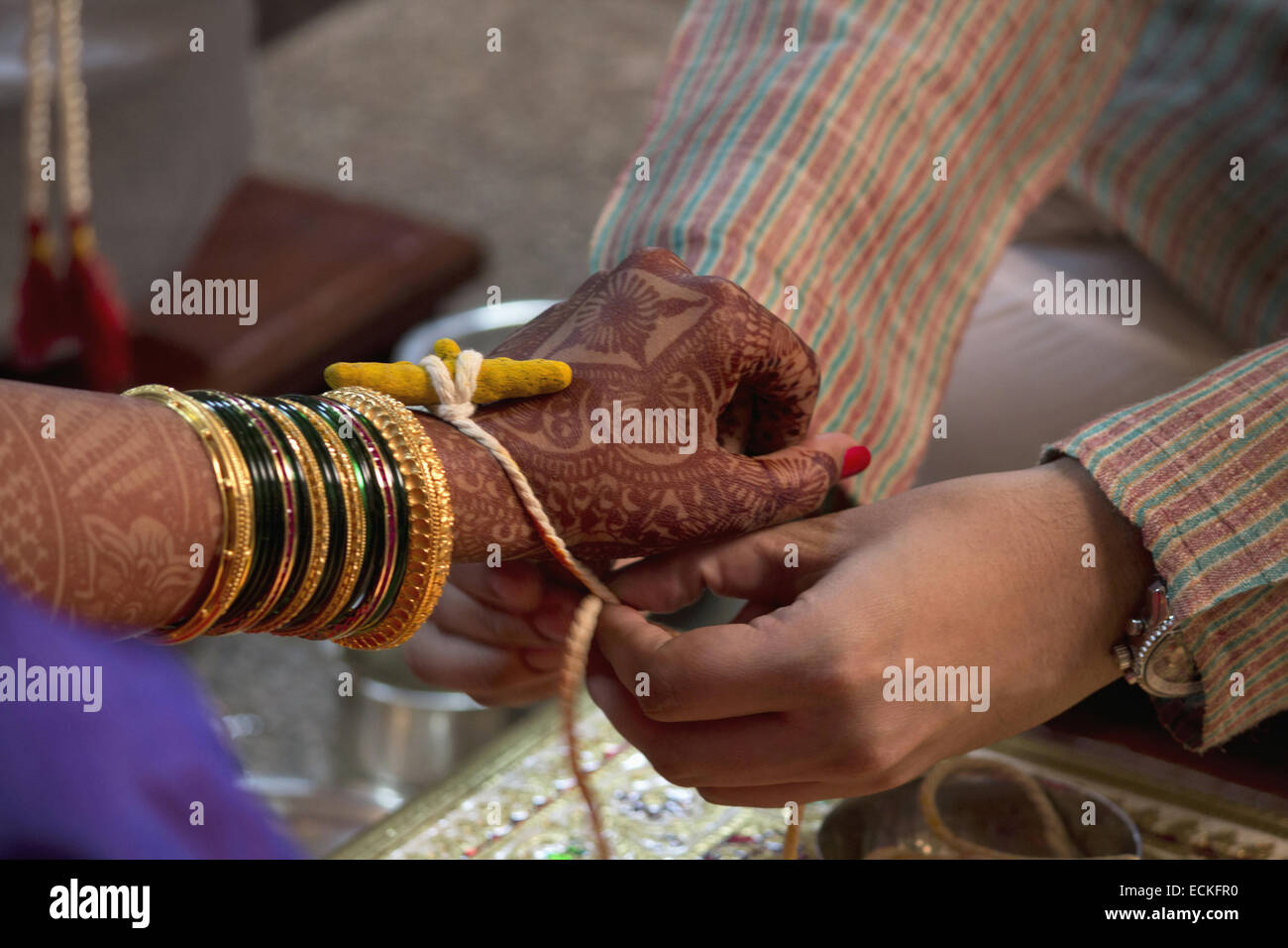 Rituel de mariage, Dhaarana Kankana, tachée de curcuma un thread enroulée autour d'une racine de curcuma. Banque D'Images