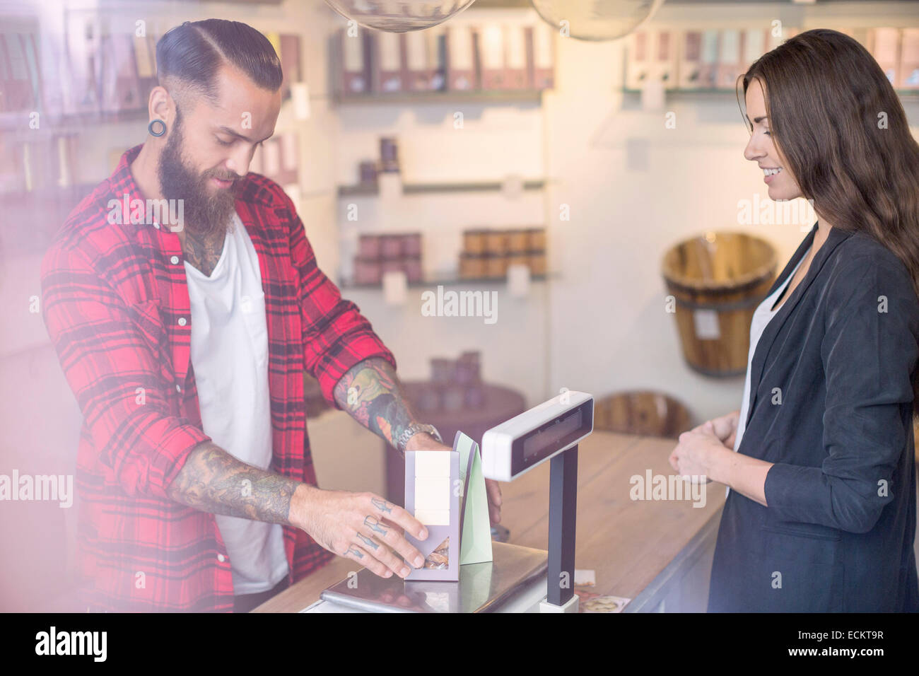 Propriétaire de bonbons dans l'avant du client en boutique Banque D'Images