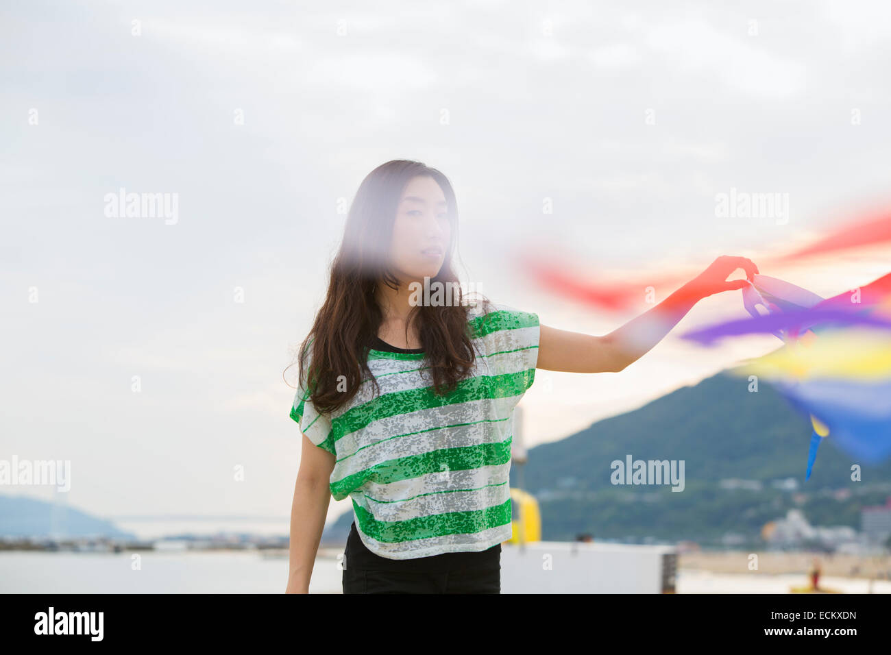 Une femme sur une plage à Kobe holding paper streamers. Banque D'Images