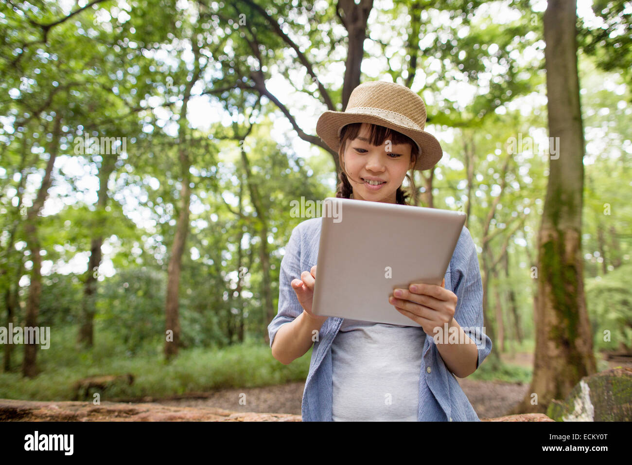 Jeune femme tenant une tablette numérique dans une forêt. Banque D'Images