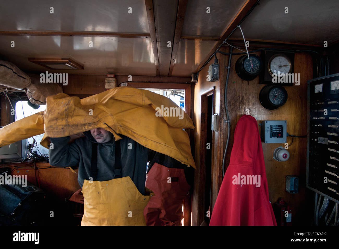 Membre de l'équipage de pont s'habille en cabine d'un chalutier de pêche. Banque D'Images