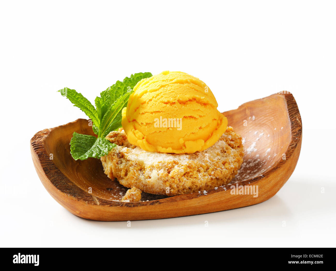 Biscuit aux amandes et boule de glace servi sur un bol en bois d'olivier Banque D'Images