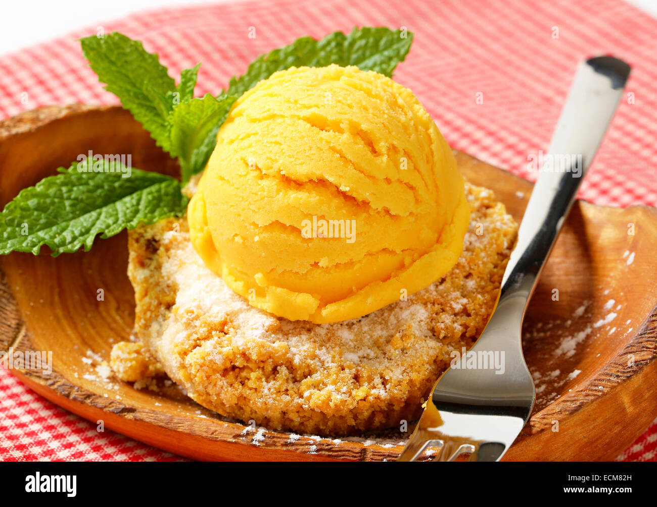 Biscuit aux amandes et boule de glace servi sur un bol en bois d'olivier Banque D'Images