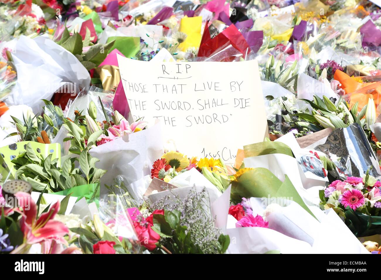 Sydney, Australie. 16 décembre 2014. Un message laissé entre les fleurs dit "R.I.P. Ceux qui vivent par l'épée. Mourra par l'épée" (paroles de Jésus Christ), à la suite de la prise d'otages terroristes inspirés d'ISIS à l'Lind Café par demandeur d'asile iranien et l'homme criminel Haron Monis. Deux otages ont été tués dans l'état de siège ainsi que le preneur d'otages. Crédit : Copyright 2014 Richard Milnes/Alamy Live News. Banque D'Images