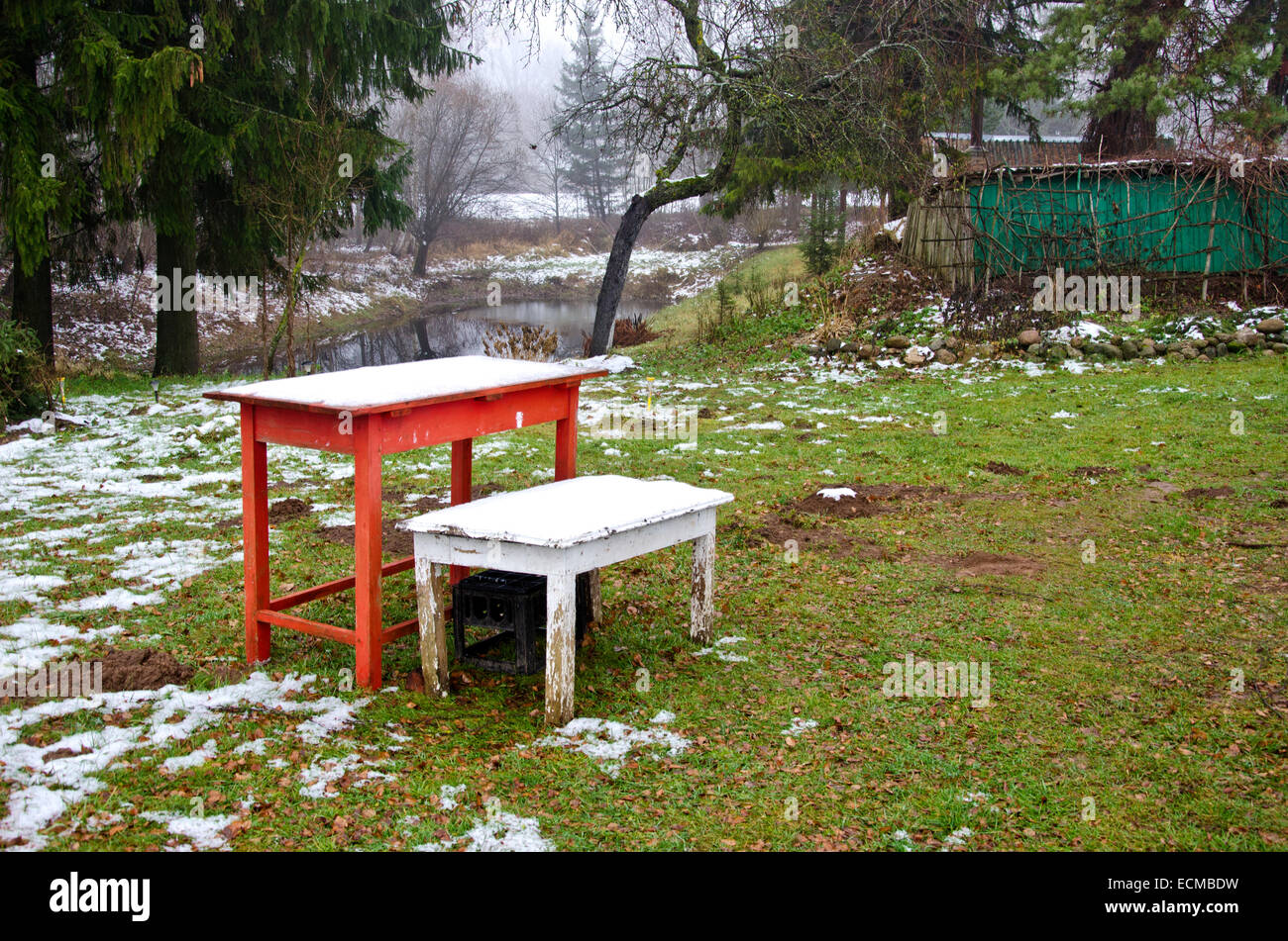 Table en bois avec deux première neige d'automne dans la région de old farm garden Banque D'Images