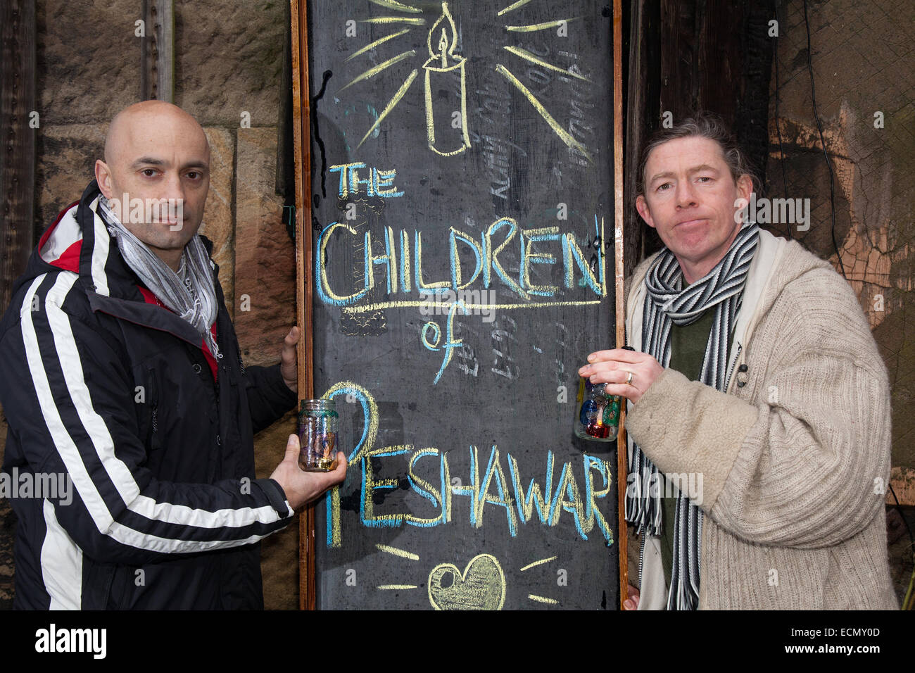 Liverpool, Merseyside, Royaume-Uni. 17 décembre 2014. "Éclairer une bougie"  Se Souvenir des enfants de Peshawar sont M. Tom Calderwell, et M. Chris Jones à l'église St Luke, Liverpool, qui est une ancienne église paroissiale anglicane, qui est maintenant une ruine. L'église a été construite entre 1811 et 1832, et a été conçue par John Foster, Senior et John Foster, junior, père et fils qui ont été des arpenteurs successifs de la Corporation municipale de Liverpool. Il a été gravement endommagé pendant le Blitz de Liverpool en 1941, et reste comme une coquille sans toit. Banque D'Images